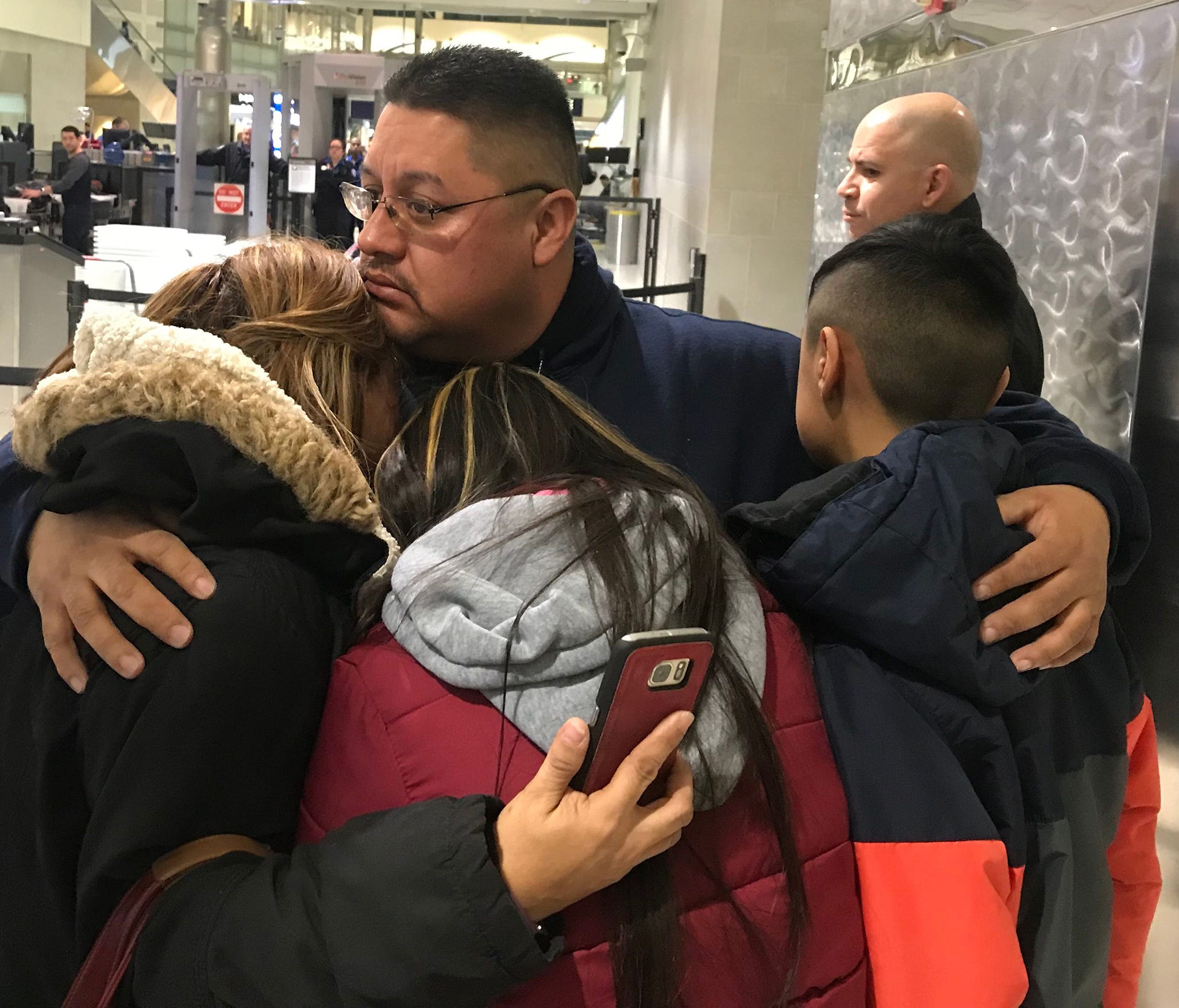 Jorge Garcia, 39, of Lincoln Park, Mich., hugs his wife, Cindy Garcia, and their two children Jan. 15, 2018, at Detroit Metro Airport moments before being forced to board a flight to Mexico to be deported.
