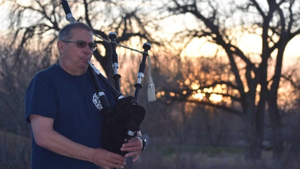 Fort Range Fire Chief Mike West plays the bagpipes