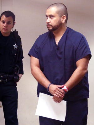 George Zimmerman, right, walks in handcuffs during a first appearance at the Seminole County Courthouse in Sanford, Fla., Jan. 10. Prosecutors said he would not be tried on aggravated-assault charges because a witness recanted her statement against him.