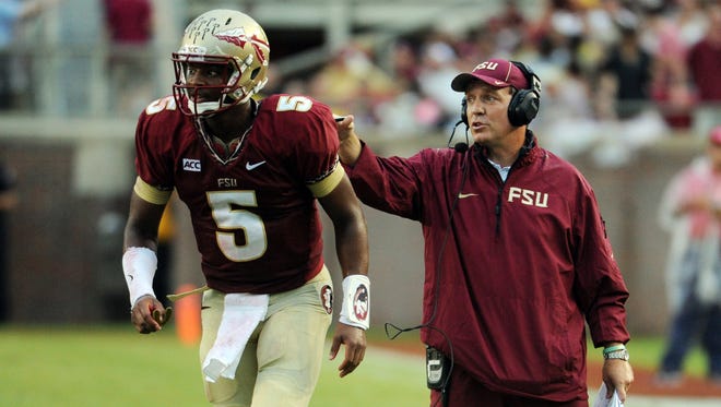 Sep 21, 2013; Tallahassee, FL, USA; Florida State Seminoles quarterback Jameis Winston (5) returns to the field after talking with head coach Jimbo Fisher during the first half of the game against the Bethune-Cookman Wildcats at Doak Campbell Stadium. Mandatory Credit: Melina Vastola-USA TODAY Sports