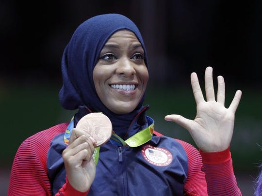 Ibtihaj Muhammad of the United States poses with her bronze medals on the podium after the women's sabre fencing event at the 2016 Summer Olympics in Rio de Janeiro, Brazil, Saturday, Aug. 13, 2016.