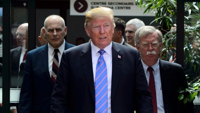 U.S. President Donald Trump leaves the G7 Leaders Summit in La Malbaie, Que., on Saturday, June 9, 2018., with White House Chief of Staff John Kelly, left, and National Security Adviser John Bolton.