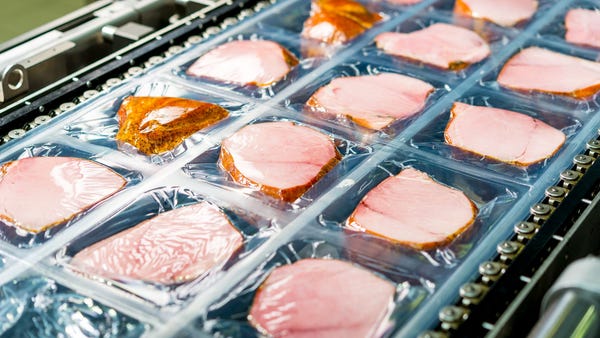 Ham being processed and packaged on an assembly li