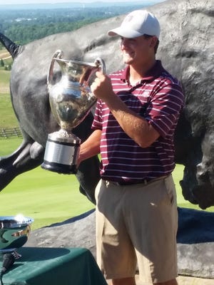 Mitch Mather hoists the traveling trophy after claiming the Missouri Amateur Championship on Sunday at the Buffalo Ridge Springs Course.