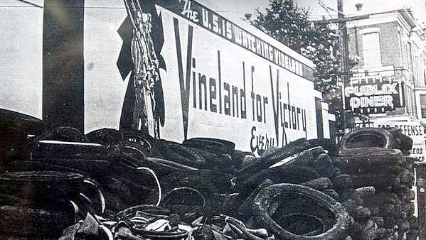 Tires and scrap to aid in the war effort are collected in front of a large "Vineland for Victory" sign during World War II.