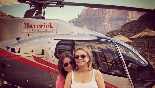 In this Oct. 21, 2014 photo provided by TheBrittanyFund.org, Brittany Maynard, left, hugs her mother Debbie Ziegler next to a helicopter at the Grand Canyon National Park in Arizona. The 29-year-old terminally ill woman has fulfilled a wish on her bucket list: visiting the Grand Canyon. Maynard, who has advanced brain cancer, has said she plans use Oregon's death-with-dignity law to end her own life Saturday, Nov. 1, 2014 though she could still change her mind. Maynard and her husband moved to Oregon from Northern California because Oregon allows terminally ill patients to end their lives with lethal medications prescribed by a doctor. (AP Photo/TheBrittanyFund.org)