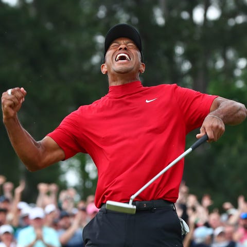 Tiger Woods celebrates after making a putt on the 