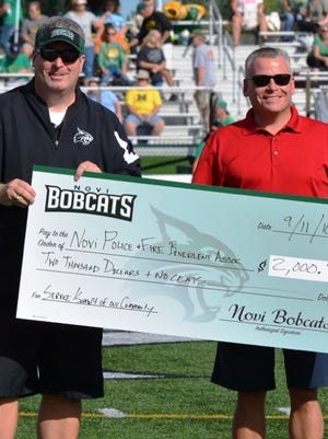 Novi Bobcats president Rob Lalain (left) presents the $2,000 check to Novi's Chief of Police David Molloy.