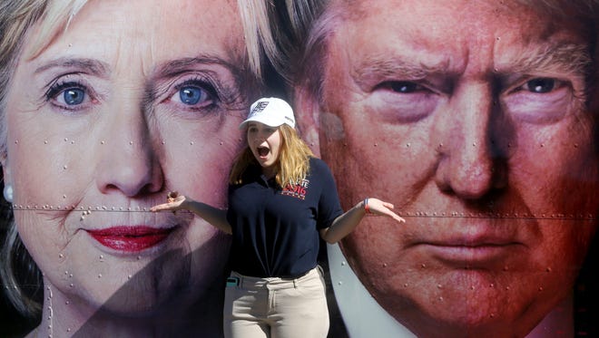 Madison Wright, 19, a student volunteer in the Hofstra University social media department, stands between images of the two presidential candidates Saturday, a day before the first presidential debate is to take place at the university in Hempstead, Long Island. 