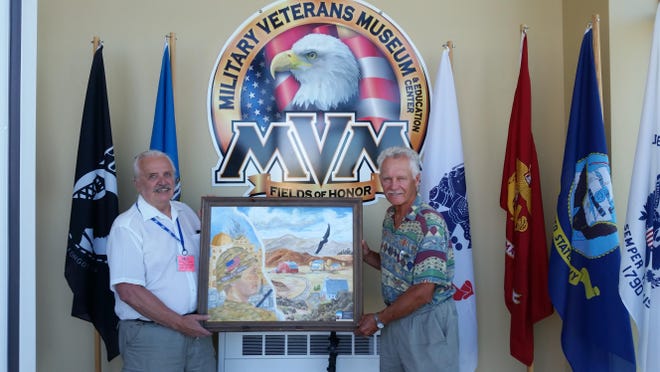 Military Veterans Museum volunteer Raymond Lorel Ellingsen Jr., left, and painter Jerry Kuiper hold Kuiper’s oil painting, “Why I Serve,” which is on temporary display at the museum.