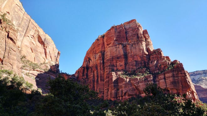 Heading out: yhe sandstone blade of Angel's Landing cuts an imposing silhouette from the base of the trail