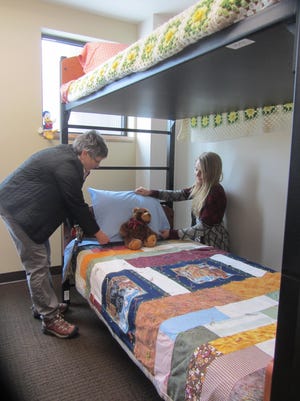 Cameron Family Center supervisors Beth Clark, left, and Debbie Kleinhasser check the bedding of an new bunk bed in a family bedroom. The first homeless families are set to be transferred to the new Great Falls Rescue Mission facility on Monday.