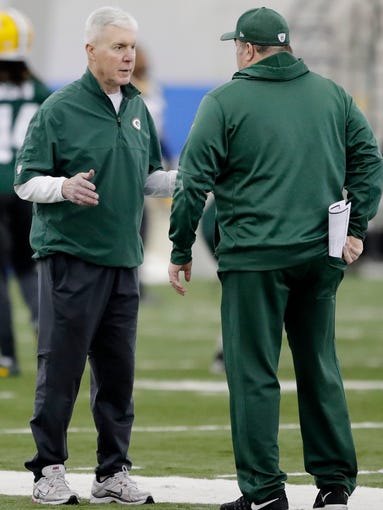 Packers GM Ted Thompson talks to head coach Mike McCarthy