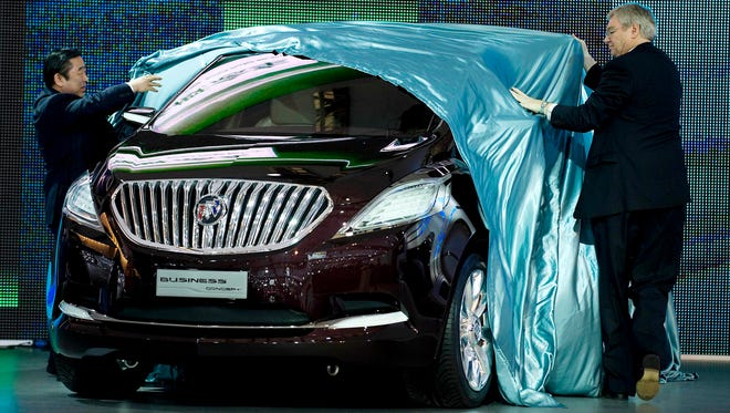 Executives unveil the Buick brand's new Business concept car at the Shanghai International Automobile Exhibition in 2009