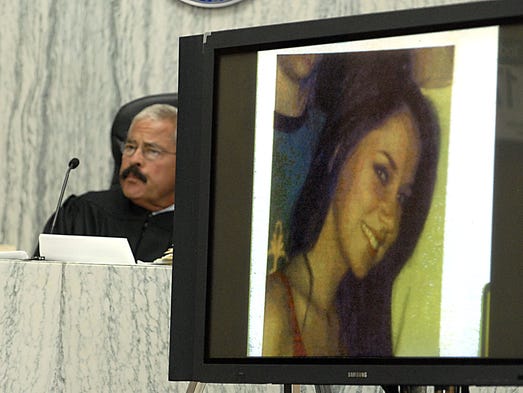 Judge Robert Perry sits behind a photograph displayed