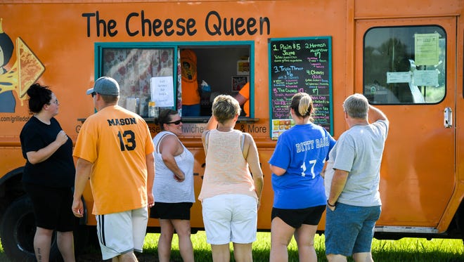 Diners lineup in front of The Cheese Queen food truck during the Food Trucks at the Farm event hosted by the Evansville Food Truck Association at Farm 57 every Wednesday, July 11, 2018.