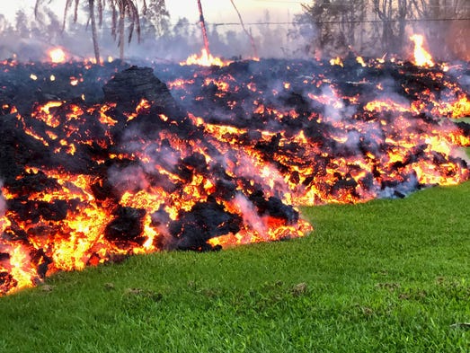 Lava flows across a yard in the Leilani Estates neighborhood