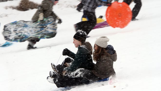 Sledders speed down a snowy hill at Donaldson Park in Highland Park in 2015.
