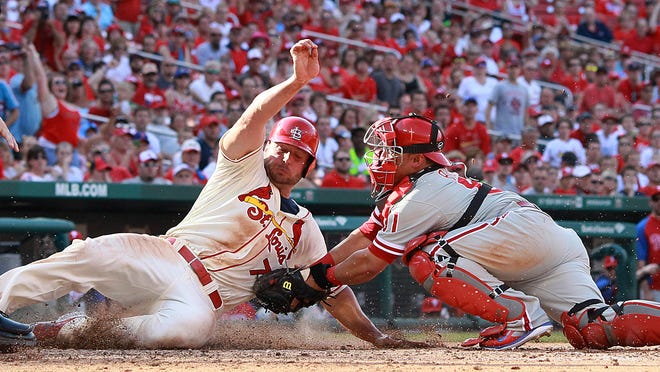 
St. Louis Cardinals outfielder Matt Holliday (left) is tagged by Philadelphia Phillies catcher Carlos Ruiz, but Ruiz was unable to hold on to the ball as Holliday scored on a fielder’s choice by Jhonny Peralta in eighth inning Saturday.
