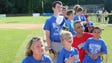 The Blue team stands along the first base line as the