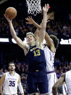 Michigan forward Moritz Wagner, left, drives to the