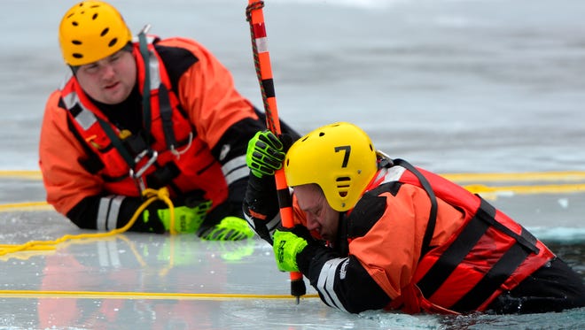Skip Urban from Wissahickon Fire Department in Montgomery County pulls himself from the water using a spike-tipped pole as rescue personnel from six different departments take part in ice rescue training in Hellam Township, Sunday Feb. 21, 2016. John A. Pavoncello photo