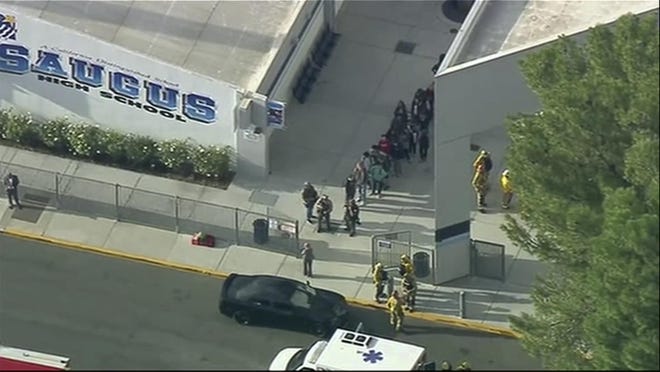 People are lead out of Saugus High School after reports of a shooting on Thursday, Nov. 14, 2019 in Santa Clarita, Calif. The Los Angeles County Sheriffâs Department says on Twitter that deputies are responding to the high school about 30 miles (48 kilometers) northwest of downtown Los Angeles. The sheriffâs office says a male suspect in black clothing was seen at the school. (KTTV-TV via AP)