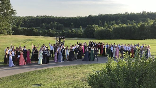 Recent Bedford High School graduates and students pose for a photo at their outdoor prom outdoor at the Stonebridge Country Club in Goffstown, N.H., organized during the coronavirus pandemic.  Amid the debate over how to reopen schools safely, some teens and parents are organizing private proms to replace events canceled because of the coronavirus.