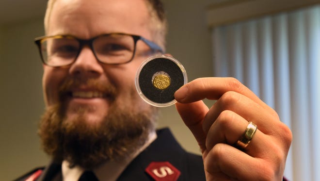 Salvation Army Lt. Jonathan Needham holds a Spanish gold coin Dec. 24, 2016, at the Salvation Army office in Vero Beach, Fla. The coin dates to a 1715 shipwreck off the Florida coast.