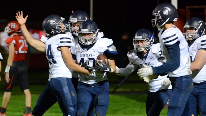 Teammates swarm Brookfield East linebacker Joey Pagel after he recovered a Sussex Hamilton fumble for a touchdown.