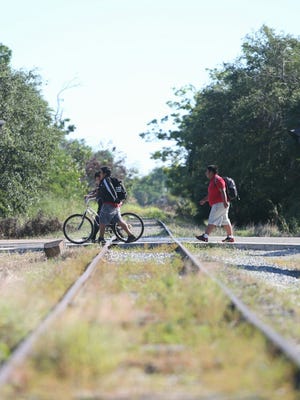 School children cross the railroad tracks at Terry Street in Bonita Springs on Thursday, Oct. 26. The city of Bonita Springs and the village of Estero are teaming up to convert the corridor into a walkable, bikeable trail.