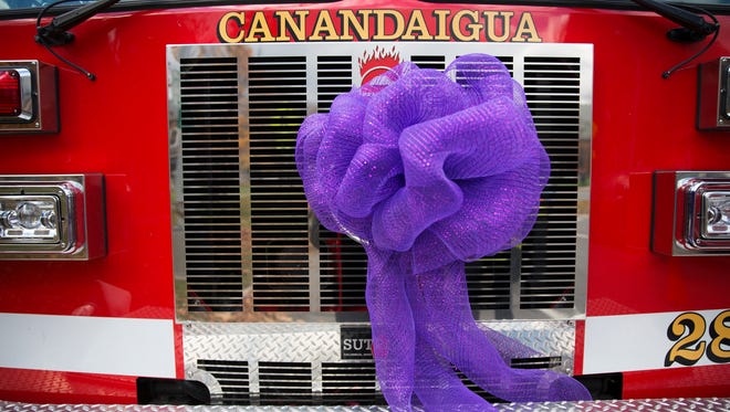 A Canandaigua fire truck is adorned with a purple bow outside of Courtney Wagner's funeral at St. Mary's Church in Canandaigua on Saturday, November 7, 2015.