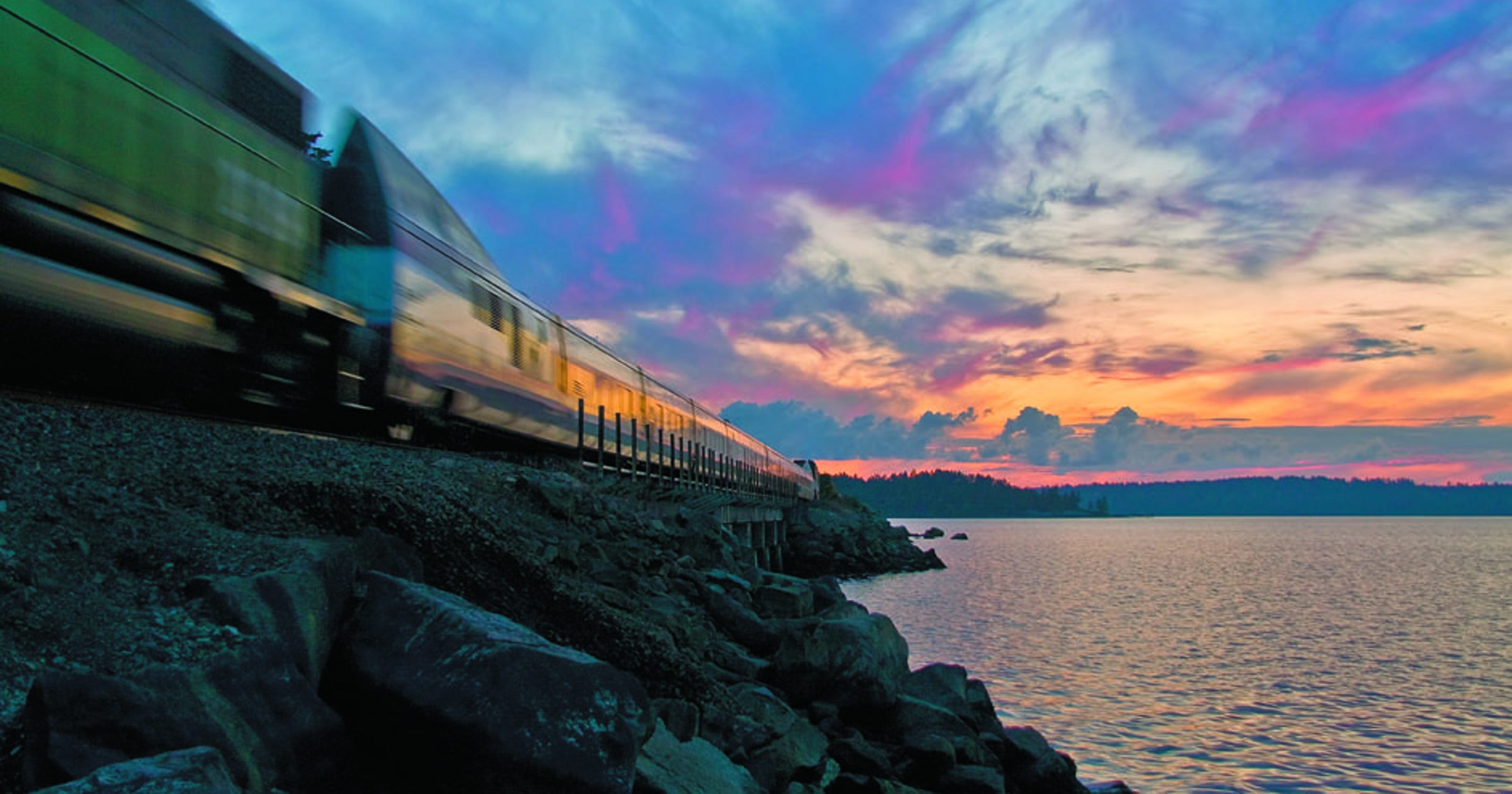 Amtrak Cascades. Amtrak person Stands near. Most of it. The scene is the most possible place