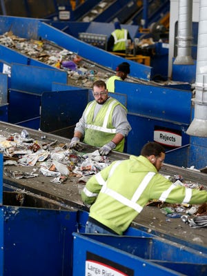 
Workers sort through paper items at the Rumpke recycling facility in St. Bernard Oct. 17, 2014.
