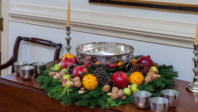 A table wreath around your favorite punch adds a festive look to your holiday party. This one, using a silver punch bowl from the Colonial Williamsburg Foundation's Collection, is part of the holiday decor for the 57th annual Christmas Homes Tour sponsored by the Green Spring Garden Club.