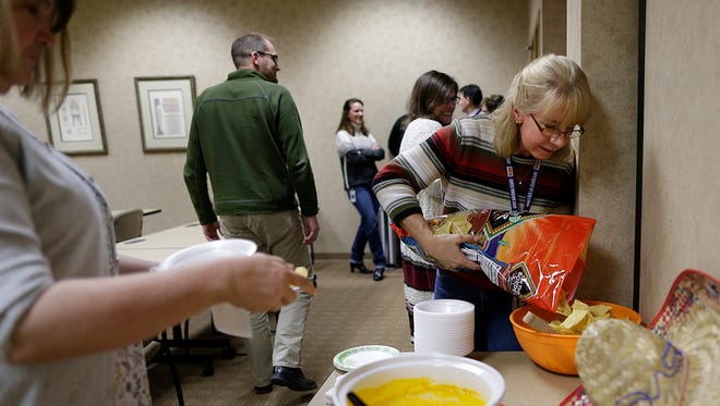 At right, Jodi Ziesmer, office assistant, fills the chip bowl as employees enjoy a nacho bar in celebration of National Tortilla Chip Day at the Wipfli office in Howard on Wednesday. Wipfli was just named the Best Next Generation Workplace for young professionals by Current, the Greater Green Bay Chamber's young professionals organization.