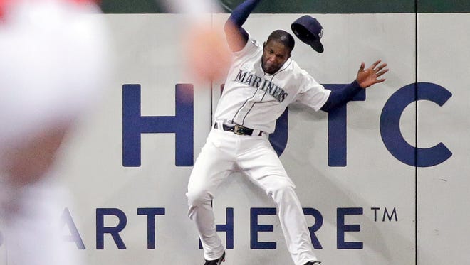 Seattle Mariners left fielder Guillermo Heredia loses his cap as he hits the wall while catching a deep fly ball from Los Angeles Angels' Andrelton Simmons during the sixth inning of Wednesday's game.