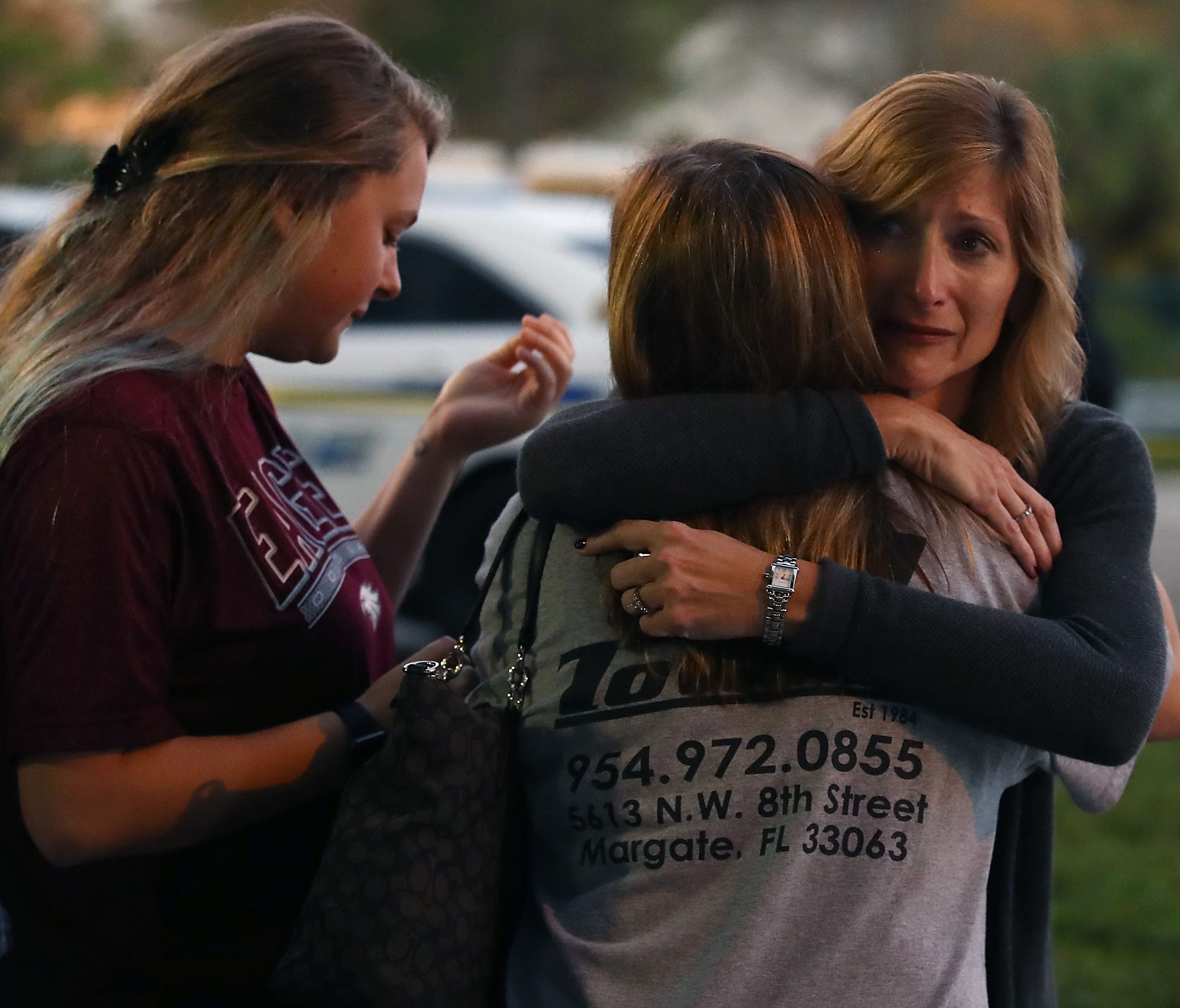 Kristi Gilroy hugs a young woman at a police check point near the Marjory Stoneman Douglas High School where 17 people were killed by a gunman yesterday, Feb. 15, 2018 in Parkland, Fla.