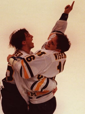 Michigan's David Oliver, left, and Brian Wiseman celebrate their championship win against Lake Superior State University during the Central Collegiate Hockey Association Championship game at Joe Louis Arena on March 20, 1994.