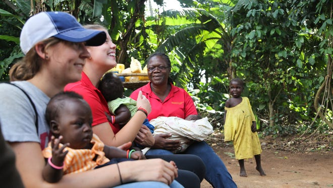 Co-leaders of the 2015 ISU service learning trip to Uganda Dorothy Masinde, right, and Elly Sukup, middle, with graduate student Elly Arganbright, watch a song-and-dance performance from grateful mothers who visit prenatal health centers run by the ISU - Uganda Program.