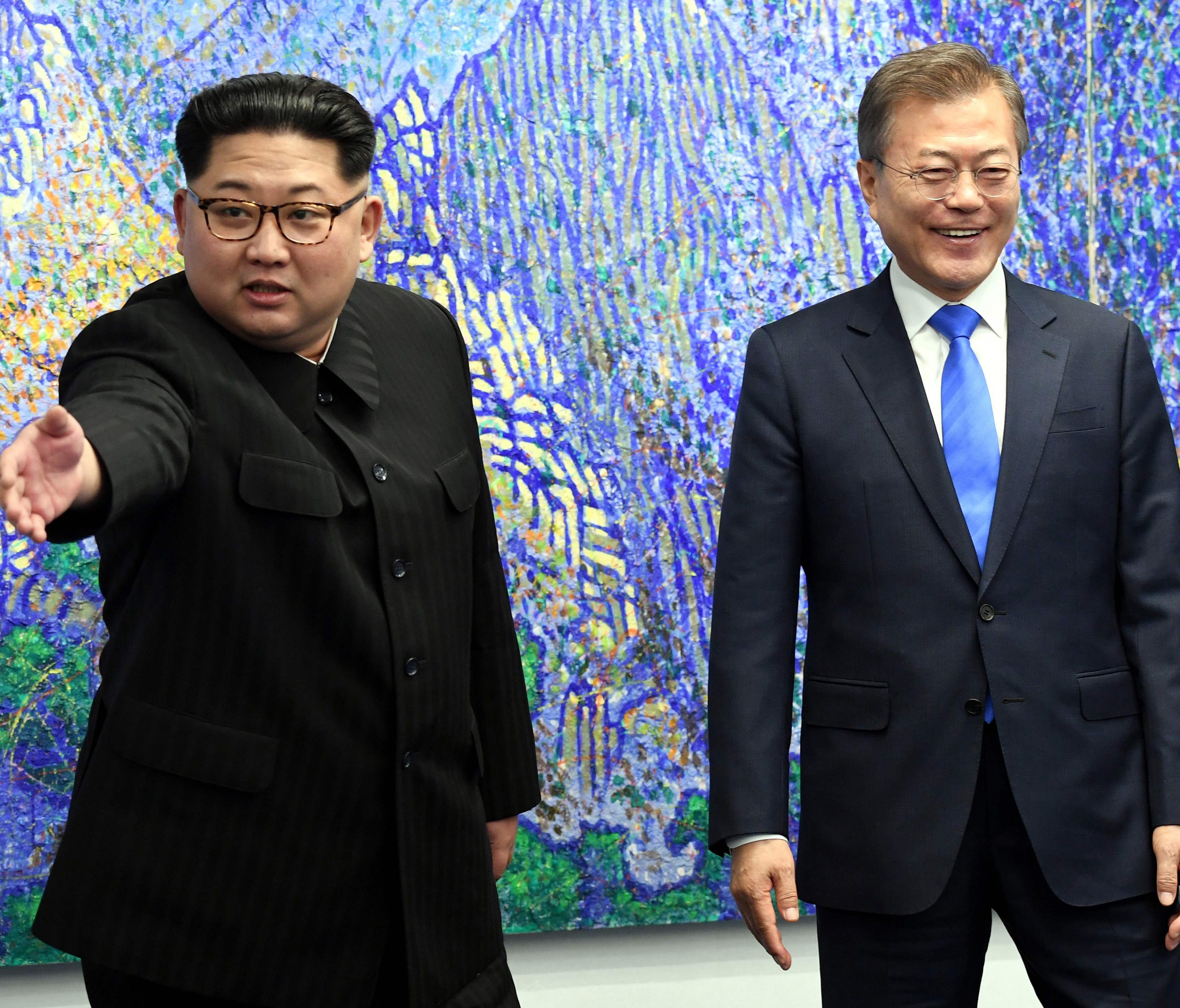 North Korea's leader Kim Jong Un (left) gestures next to South Korea's President Moon Jae-in (right) as they pose for a photo during the Inter-Korean summit in the Peace House building on the southern side of the truce village of Panmunjom.