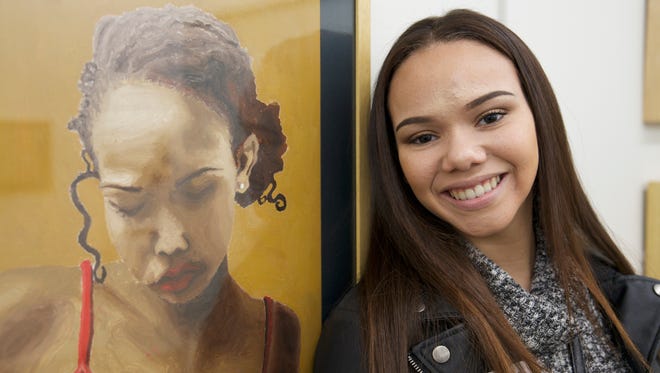 Samara Abdul-Allah, a senior at Roberson High School, stands next to
her oil painting "Red Shirt," a gold key winner in the Regional
Scholastic Art Awards competition.