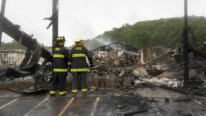 Fruitdale VFD firemen survey the leveled auditorium area of the Little Nashville Opry as Brown County VFD firefighters spray more water on the remains of the building near Nashville, Ind. Sunday, Sept. 20, 2009. Fire investigators were searching for the cause of the blaze that destroyed the popular country music concert venue late Saturday night. The building was already empty from an earlier concert and there were no injuries.