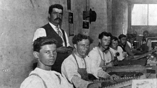 Julius Adams, owner of Julius Adams Cigar Factory, stands behind employees of his downtown St. Cloud factory circa 1900. Pictured sitting, from left, are Herman Schack and Louis Gerard.