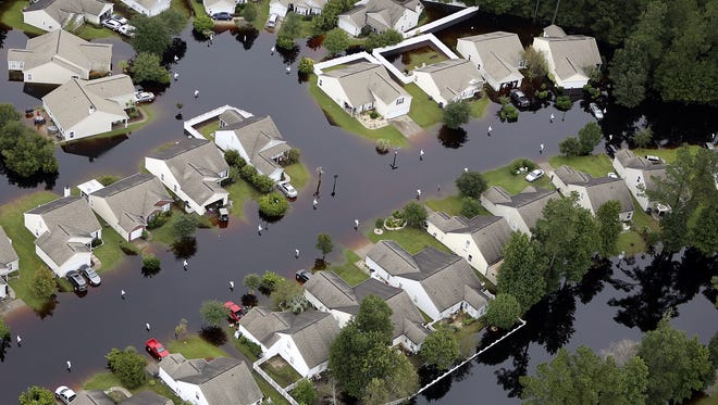 This aerial photo show flooding around homes in the Carolina Forest community in Horry County, between Conway and Myrtle Beach, S.C. The Carolinas saw sunshine Tuesday after days of inundation, but it could take weeks to recover from being pummeled by a historic rainstorm that caused widespread flooding and multiple deaths. (Janet Blackmon Morgan/The Sun News via AP)