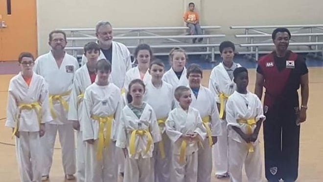 Students taking part in the Yellow Belt ceremony at the JFK Center pose for a group photo.