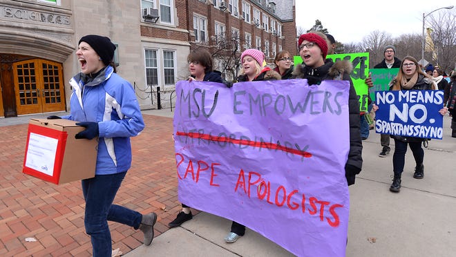 Protesters opposed to the upcoming speech by controversial columnist George Will march through campus in East Lansing Wednesday 12/10/2014. The group took boxes of petitions opposing Will's visit to the office of MSU President Lou Anna Simon.