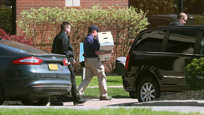 Federal agents leave the offices of Morgan Management LLC in Perinton as they conducted a raid and collected items from the building for an investigation.