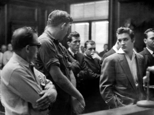 Elvis Presley in a Memphis city court on Oct. 19, 1956, along with Gulf service station employees Edd Hopper (left) and Aubrey Brown. The trio had a fight the previous night when Elvis pulled into the station at Gayoso and Second for repairs and was besieged by fans. Hopper, the station manager, ordered Presley away and a brief altercation ensued. All three were booked for assault and battery and disorderly conduct. Charges against Presley were dismissed. Hopper and Brown both had to pay fines.