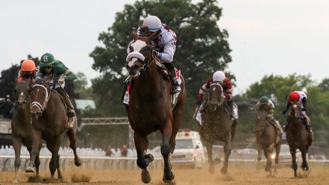 FILE - In this June 20, 2020, file photo, Tiz the Law, center, with jockey Manny Franco up, crosses the finish line to win the 152nd running of the Belmont Stakes horse race at Belmont Park in Elmont, N.Y. After an out-of-order Triple Crown with a different horse winning the Belmont, Kentucky Derby and Preakness, it might be a long time until Tiz the Law, Authentic and Swiss Skydiver all race against one another. That is, unless Swiss Skydiver challenges them and older males in the Breeders' Cup Classic on Nov. 7, which is expected to be a Tiz the Law/Authentic rematch.(AP Photo/Seth Wenig, File)